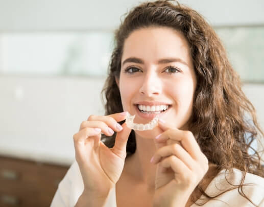 Woman placing Invisalign clear braces tray